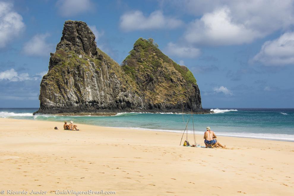 Imagem de três turistas admirando o mar da Praia da Cacimba do Padre.